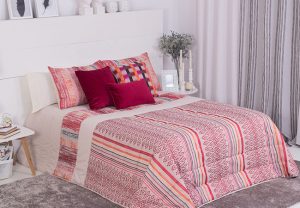Decorar con estampados. Colcha roja con cojines.